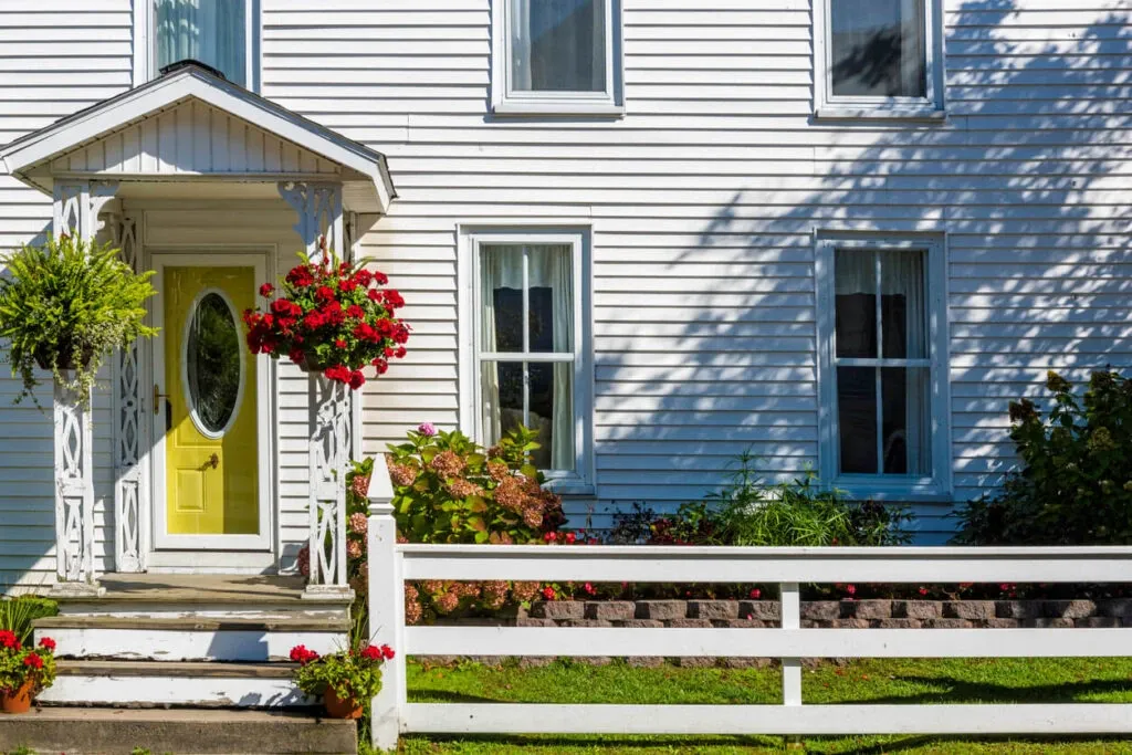 vibrant-yellow-door-floral-accents-exterior-remodeling-2024-1024x683.webp
